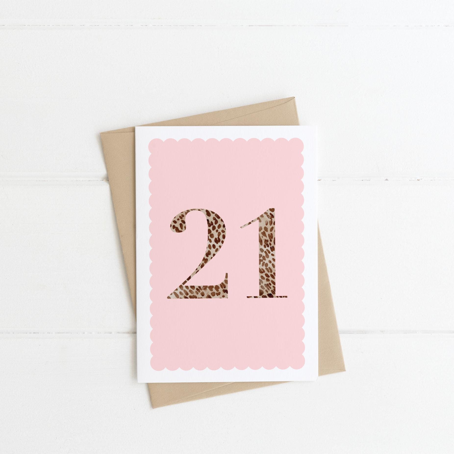 A 21st birthday card with animal print number 21 on a pastel pink background, with a kraft brown envelope