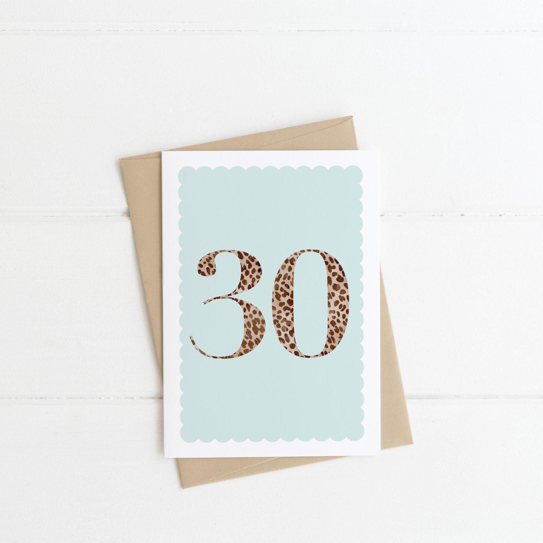 A 30th birthday card with animal print number 30 on a pastel blue background, with a kraft brown envelope