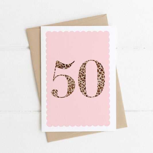 A 50th birthday card with animal print number 50 on a pastel pink background, with a kraft brown envelope