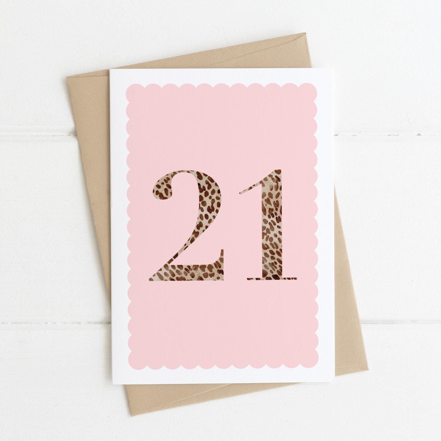 A 21st birthday card with animal print number 21 on a pastel pink background, with a kraft brown envelope