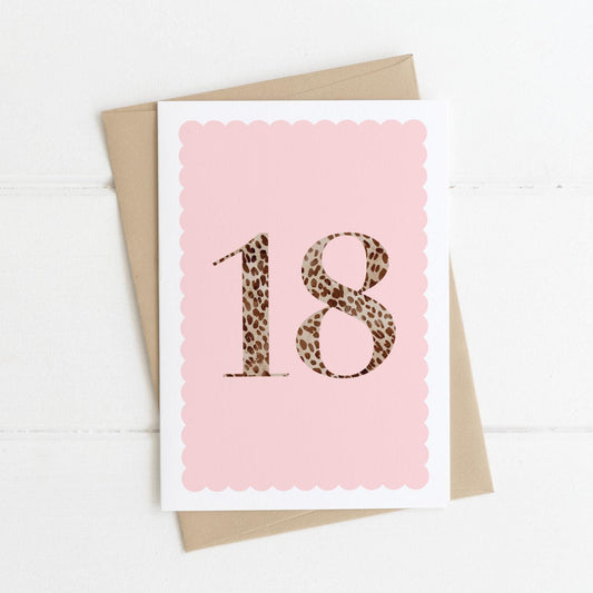 A 18th birthday card with animal print number 18 on a pastel pink background, with a kraft brown envelope