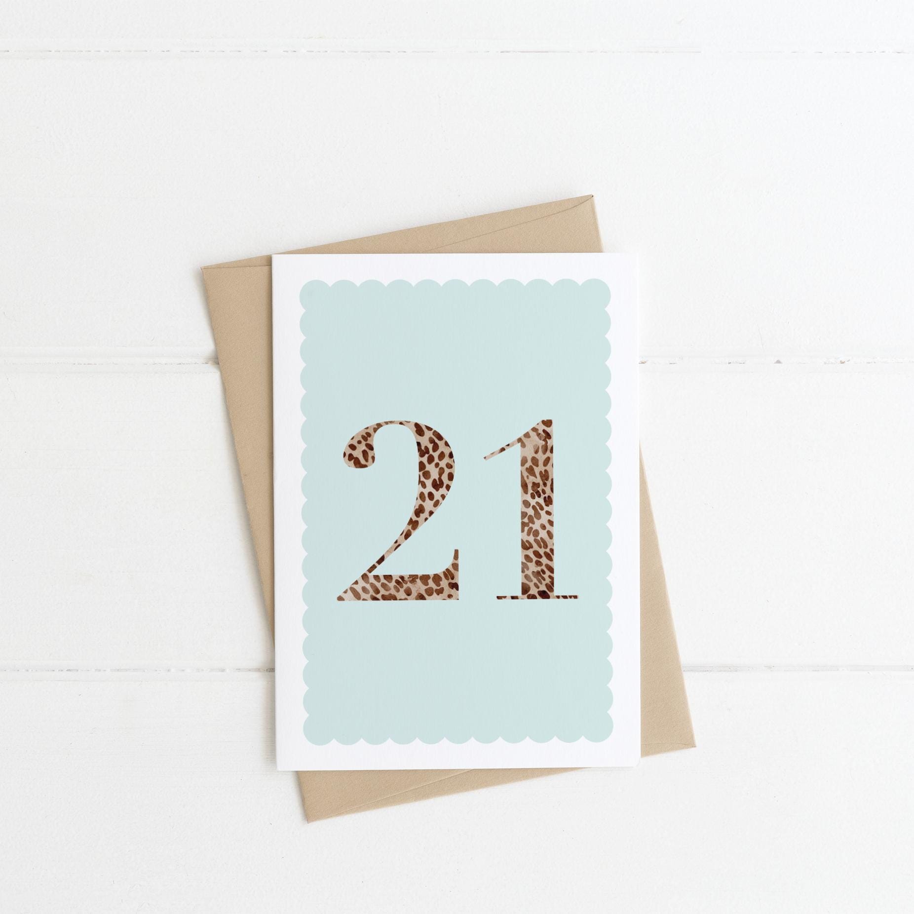 A 21st birthday card with animal print number 21 on a pastel blue background, with a kraft brown envelope