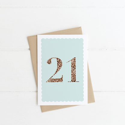A 21st birthday card with animal print number 21 on a pastel blue background, with a kraft brown envelope