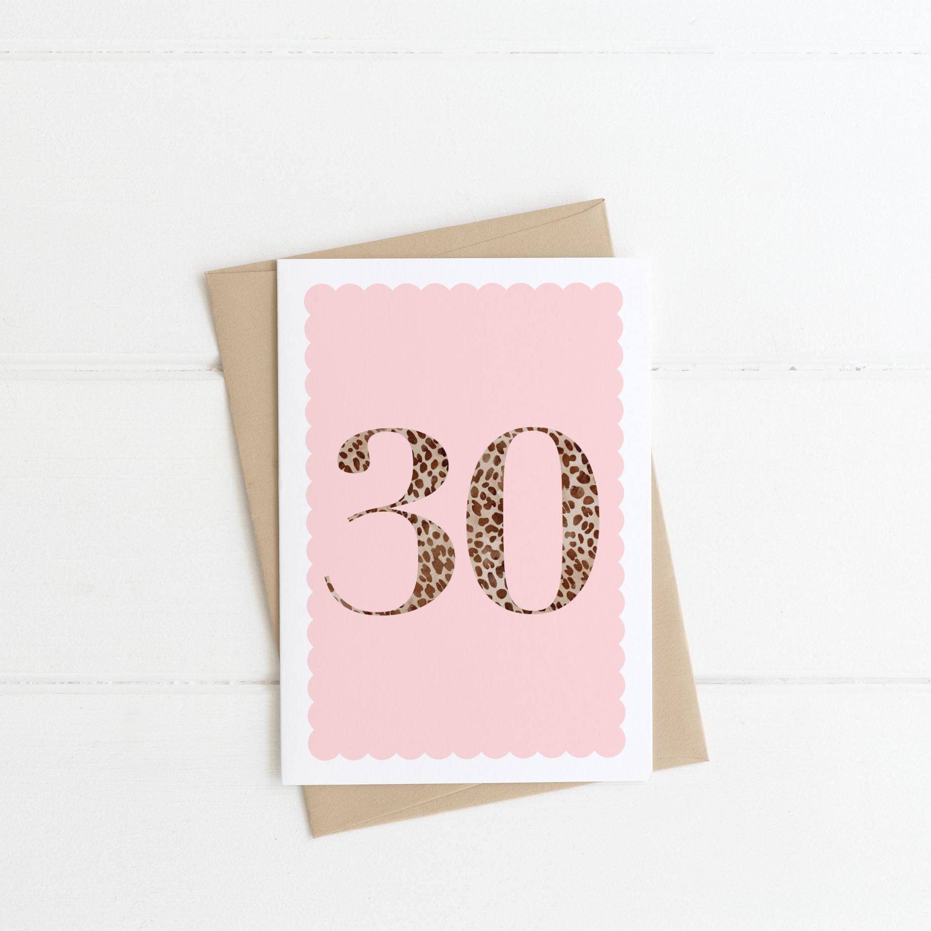 A 30th birthday card with animal print number 30 on a pastel pink background, with a kraft brown envelope