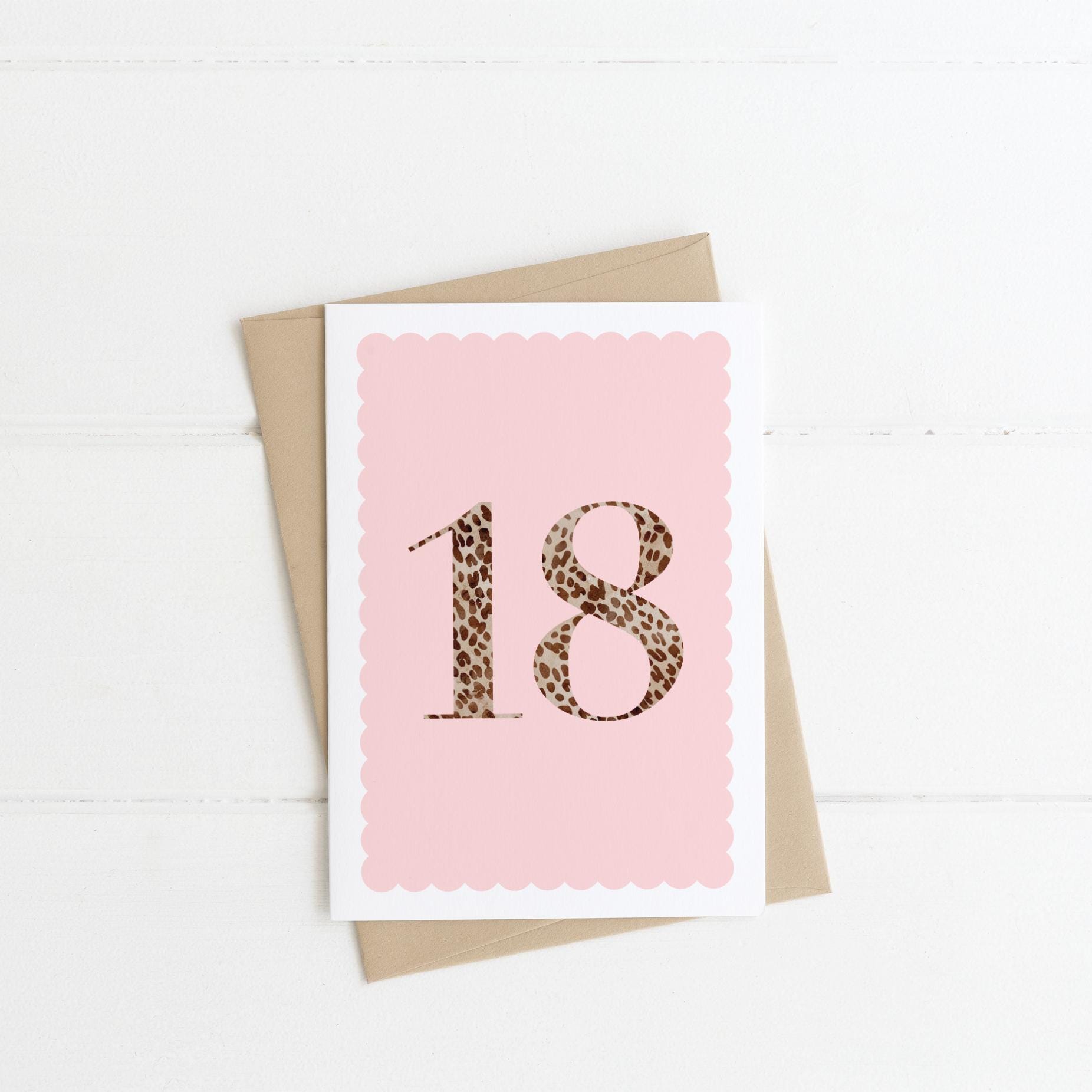 A 18th birthday card with animal print number 18 on a pastel pink background, with a kraft brown envelope