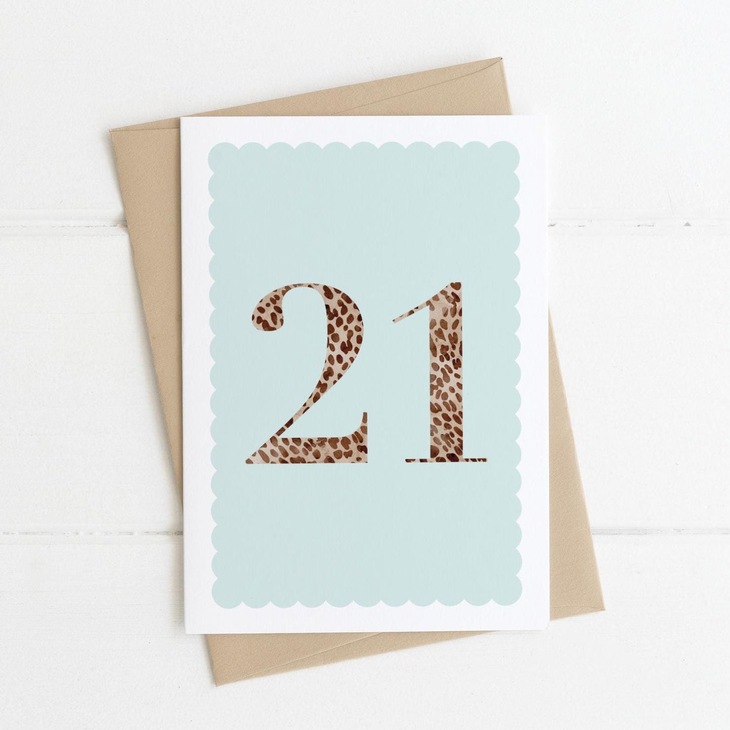 A 21st birthday card with animal print number 21 on a pastel blue background, with a kraft brown envelope