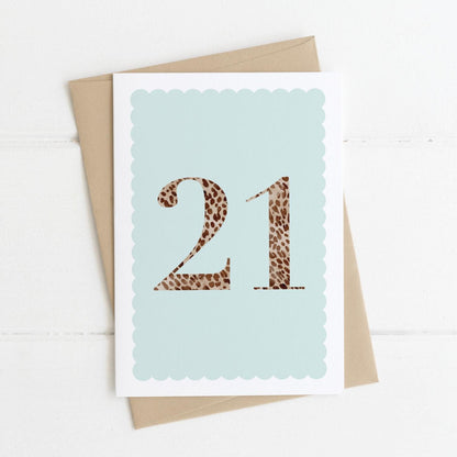 A 21st birthday card with animal print number 21 on a pastel blue background, with a kraft brown envelope