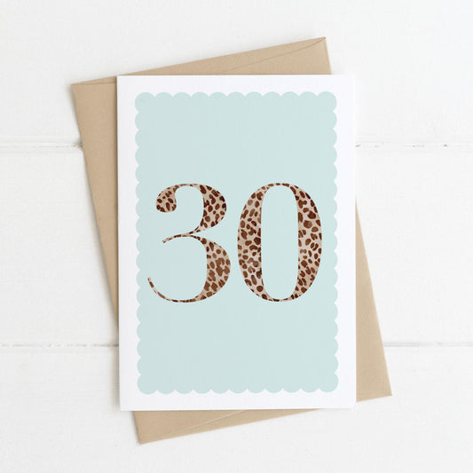 A 30th birthday card with animal print number 30 on a pastel blue background, with a kraft brown envelope